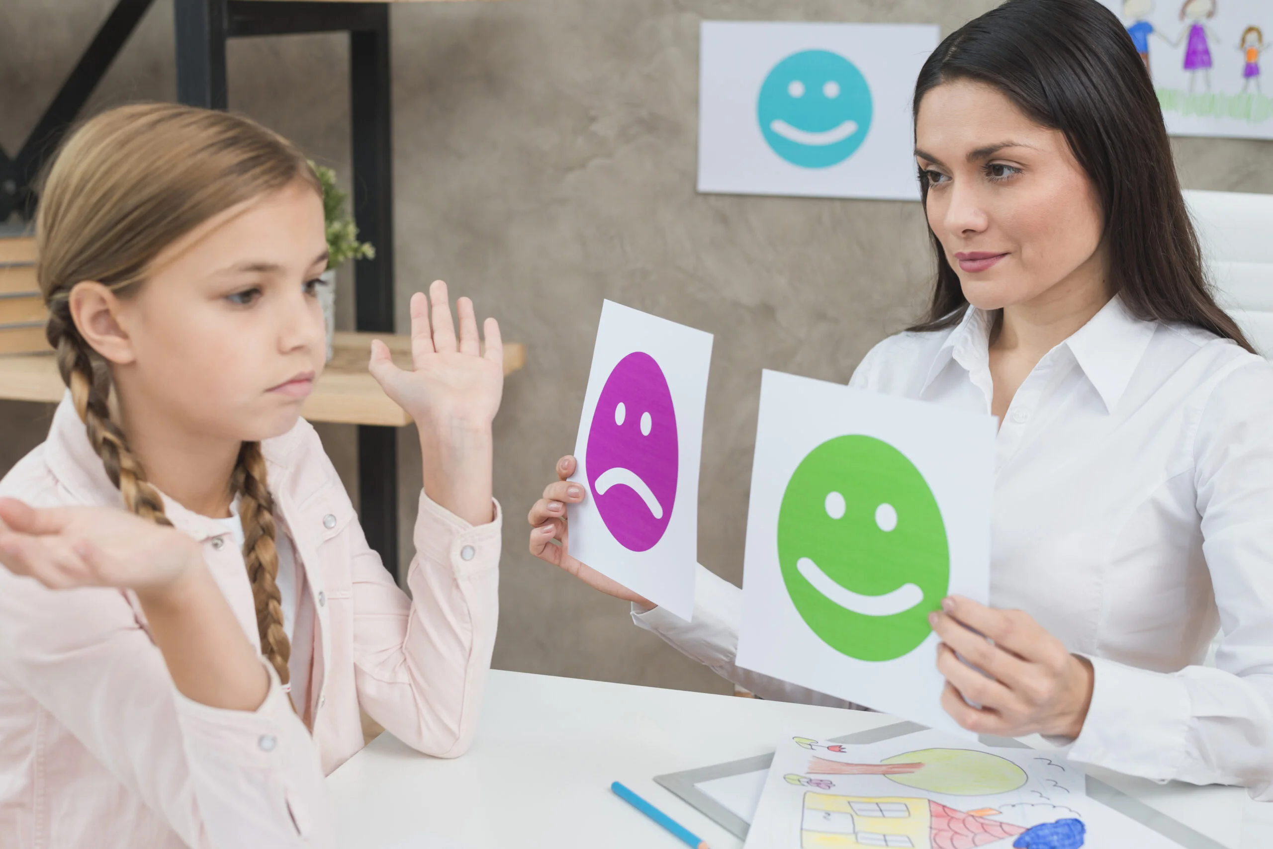 smiling-psychologist-showing-happy-sad-emotion-faces-cards-girl-child-1