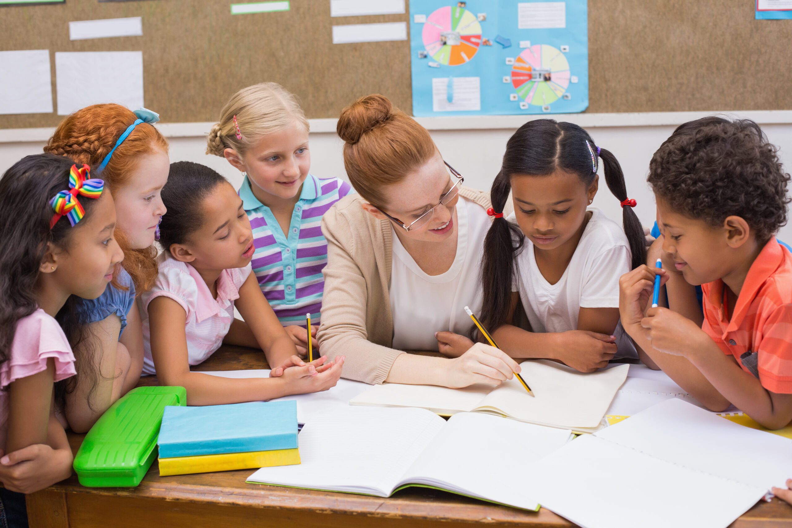 teacher-pupils-working-desk-together-1