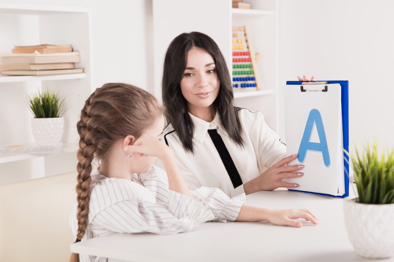 woman-with-kid-girl-training-speech-together-sitting-white-room-1536x1024-1